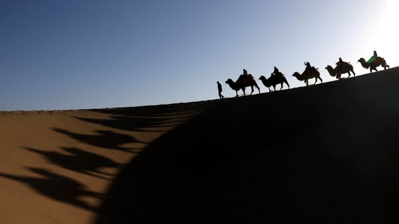<strong>Dunhuang, China: </strong>A camel train moves through the Gobi Desert. Dunhuang, in northwest China's Gansu Province, is renowned for the beauty of the Singing Sand Dune (Mingsha Hill) and Crescent Spring scenic area. <br />