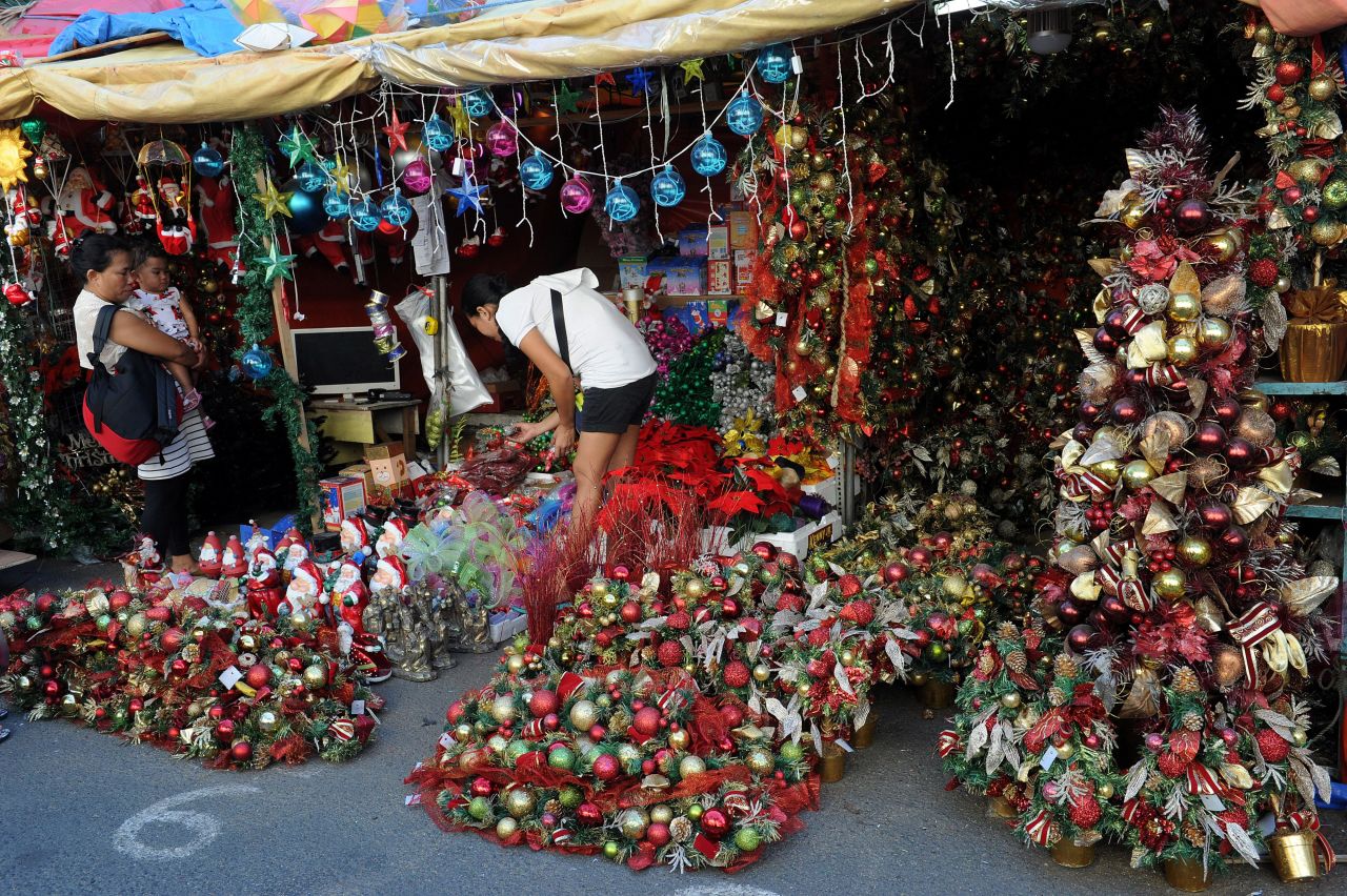 Customers buy Christmas decorations from a street stall at the farmer's market in suburban Manila.  The Philippines is Asia's bastion of Roman Catholicism and celebrates the world's longest Christmas season.