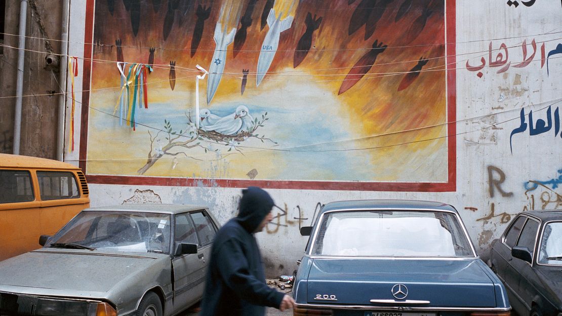 A man passes a mural painted on a wall in southern Beirut in 2006.