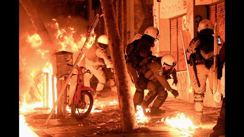 A petrol bomb explodes next to police in Athens, Greece, on Friday, November 17. Protesters began clashing with police after a rally that commemorated a 1973 student uprising.