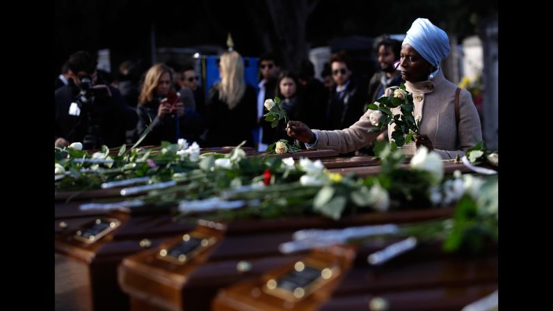 A woman in Salerno, Italy, places flowers on coffins Friday, November 17, during <a href="http://www.cnn.com/2017/11/17/europe/salerno-migrants-funeral/index.html" target="_blank">the funeral service</a> for 26 Nigerian migrants who died while crossing the Mediterranean Sea. The 26 women and girls were in a rubber dinghy that capsized in the Mediterranean on November 5.