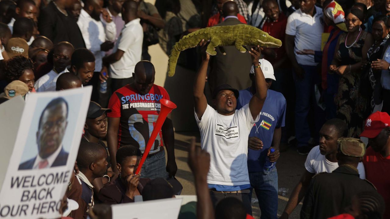 A supporter holds up a toy to welcome Emmerson Mnangagwa, known as "The Crocodile," back to the country on Wednesday in Harare. 
