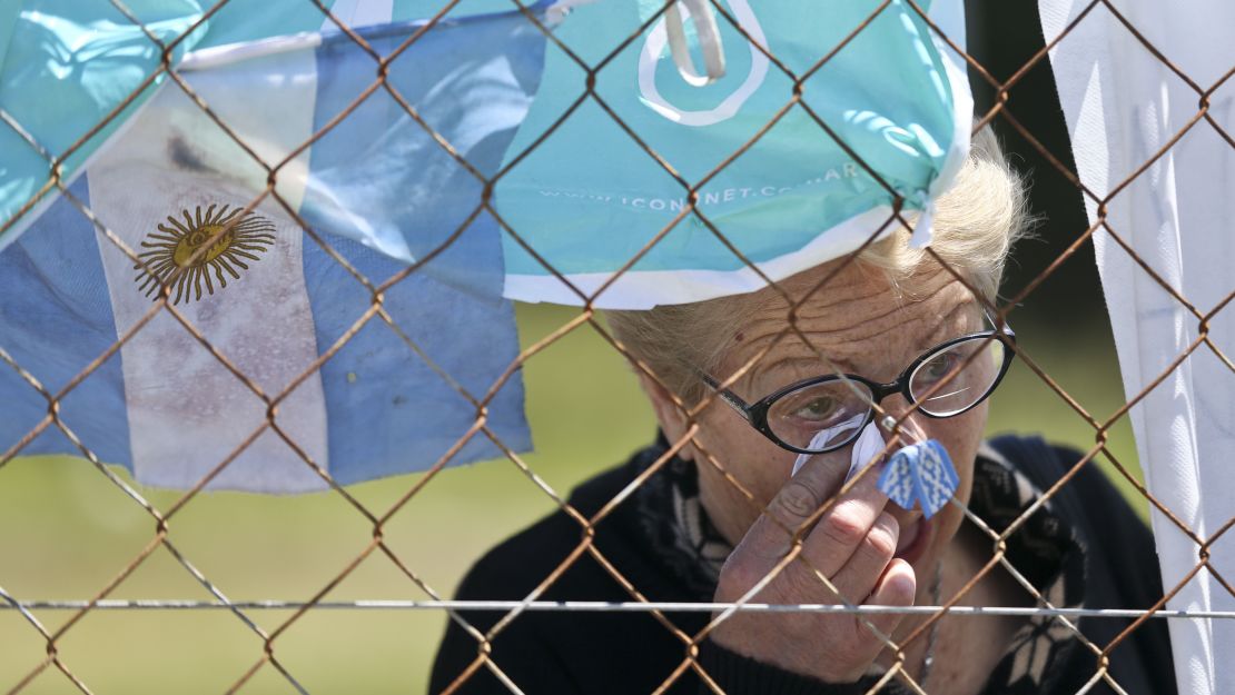 A woman cries Thursday in front of a fence enclosing the Mar del Plata naval base after learning that Argentina's navy announced that a sound detected during the search for the missing ARA San Juan submarine is consistent with that of an explosion.