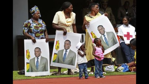 People hold portraits of Mnangagwa before the start of the inauguration.