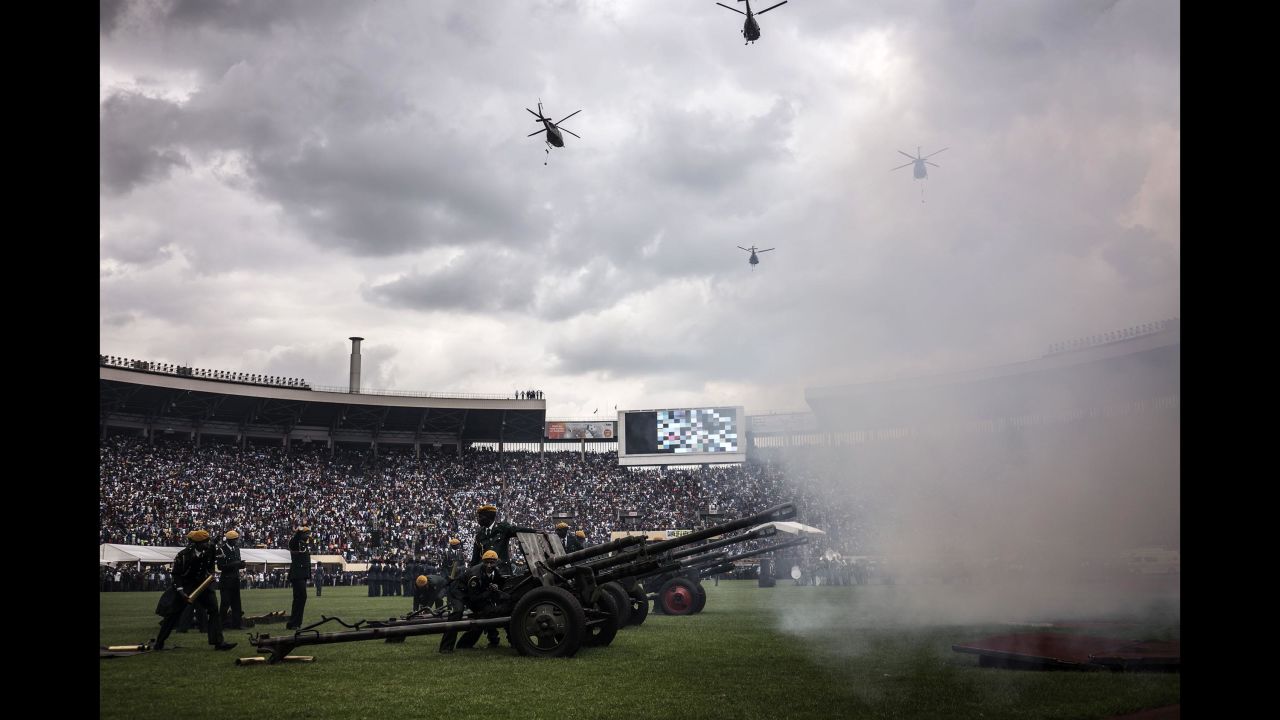 Helicopters fly over the National Sports Stadium as a battery of artillery fires salvos during the ceremony.