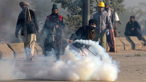 A Pakistani protester throws a tear gas shell back towards police during a clash in Islamabad on November 25, 2017.