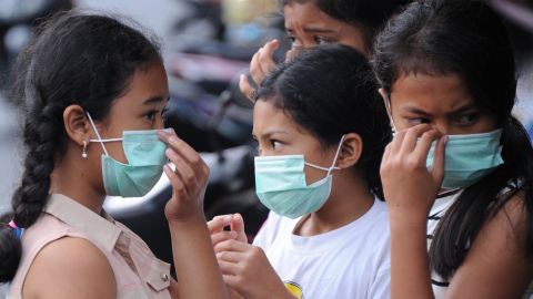 Young people put on masks due to ash in the air.