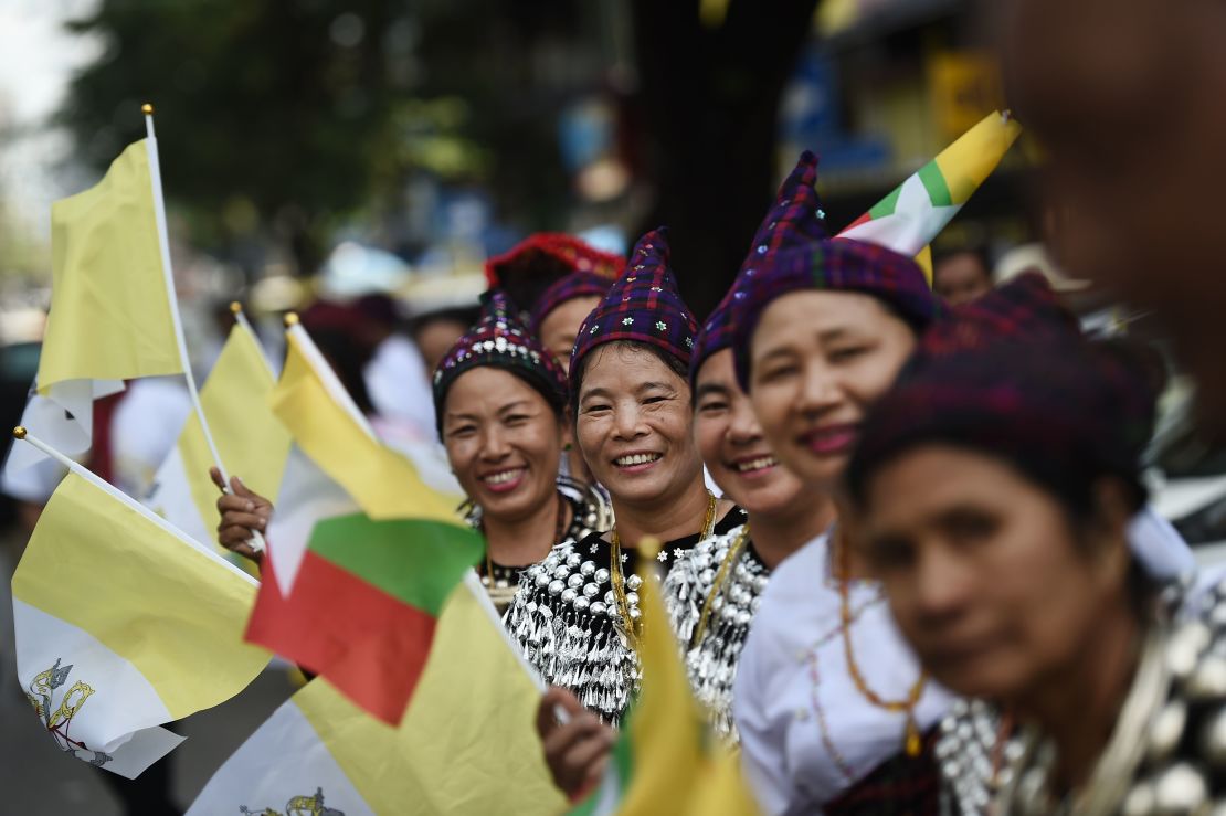 Ethnic Kachin people in traditional dress wait along a street in Yangon on Monday with the hopes of seeing Pope Francis on his way from the airport after arrival.