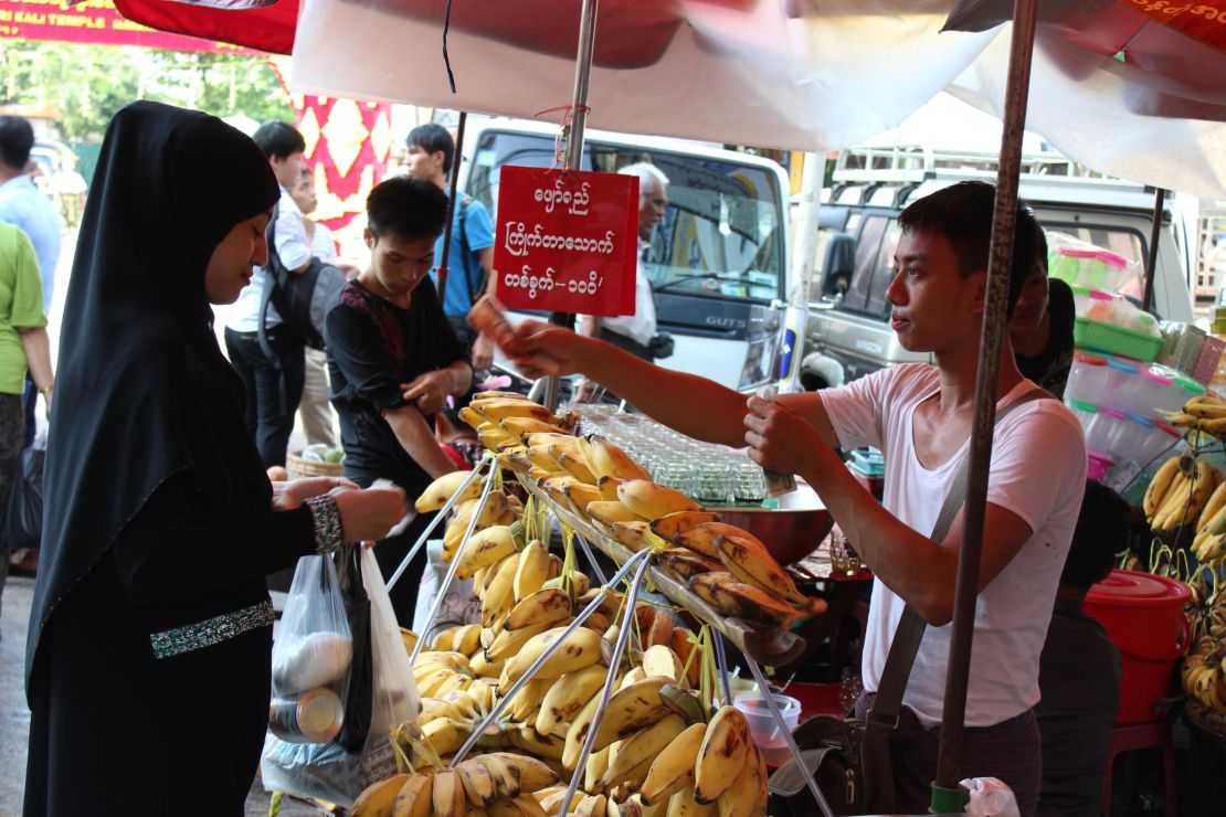 A woman wearing a veil buys bananas in central Yangon on September, 21, 2017. 