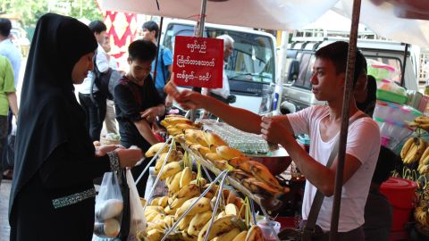 A woman wearing a veil buys bananas in central Yangon on September, 21, 2017. 