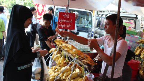 A woman wearing a veil buys bananas in central Yangon on September, 21, 2017.