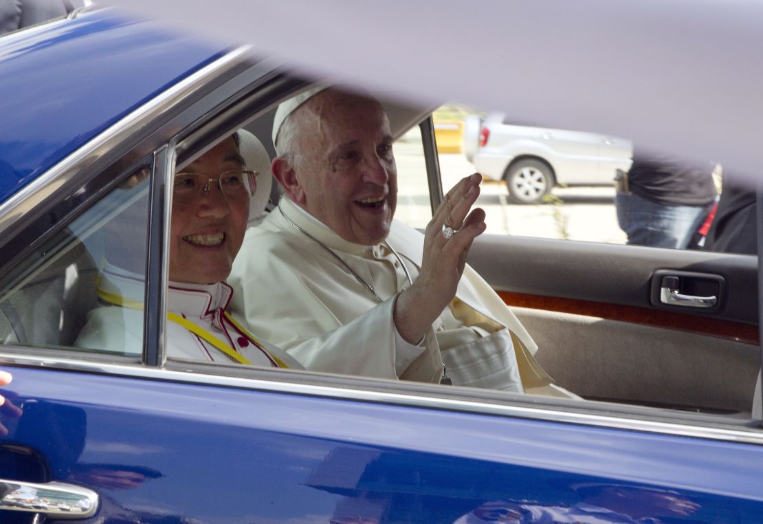 Pope Francis, right, waves upon arrival at Yangon International Airport on Monday in Yangon, Myanmar.
