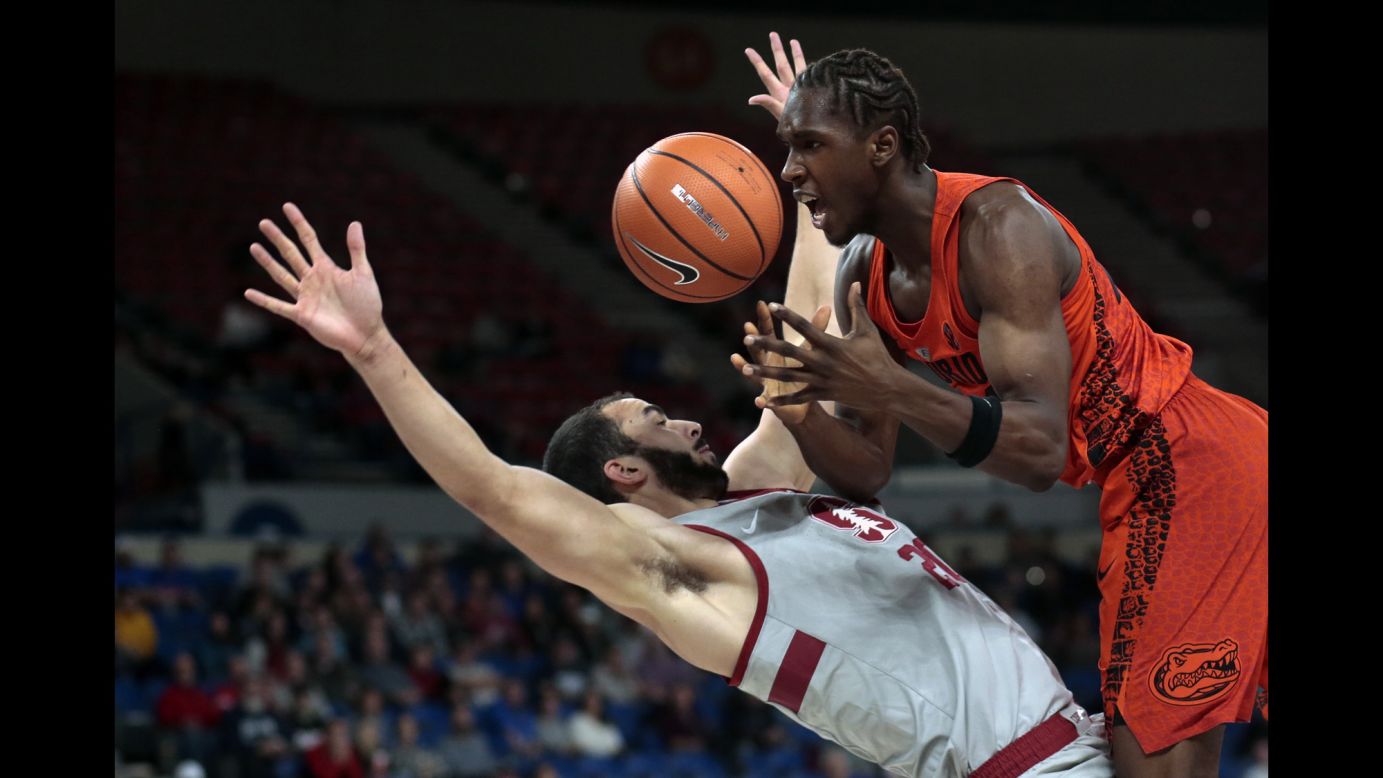 Stanford's Josh Sharma, left, draws a charge on Florida's Deaundre Ballard during a college basketball game in Portland, Oregon, on Thursday, November 23.