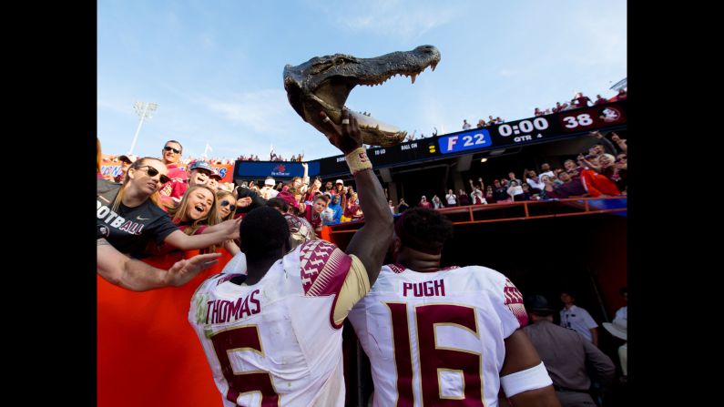 Florida State's Matthew Thomas carries a alligator head out of Ben Hill Griffin Stadium after the Seminoles defeated their rivals, the Florida Gators, on Saturday, November 25.