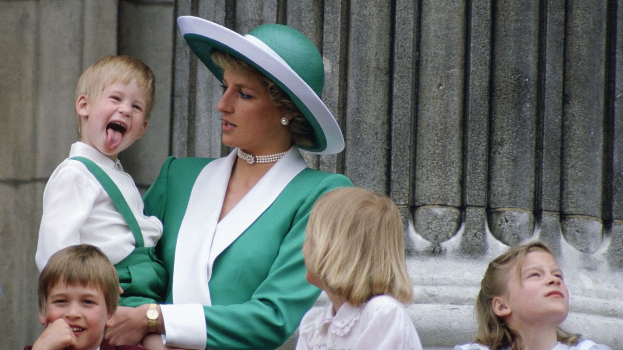 Harry sticks his tongue out, much to the surprise of his mother, at Buckingham Palace in 1988.