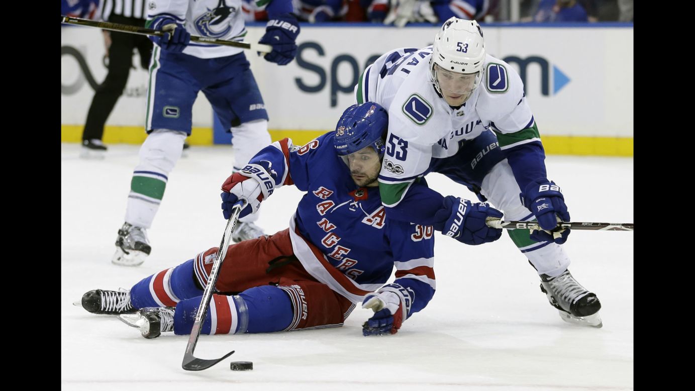 New York Rangers forward Mats Zuccarello tries to corral the puck near Vancouver's Bo Horvat during an NHL game in New York on Sunday, November 26.
