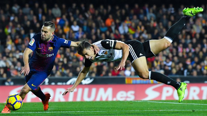 Barcelona's Jordi Alba, left, dribbles by Valencia's Gabriel Paulista during a Spanish league match in Valencia on Sunday, November 26.