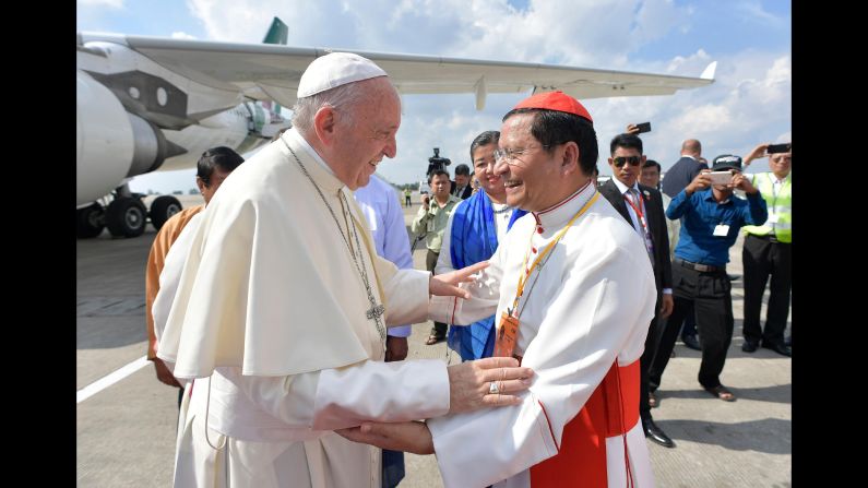 Pope Francis is received on the tarmac by Cardinal Charles Maung Bo, the archbishop of Naypyidaw.