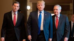 US President Donald Trump (C) with Senate Majority Leader Mitch McConnell (R) and US Senator John Barrasso (L), Republican of Wyoming, arrive for a meeting with the Republican Senate Caucus at the US Capitol in Washington, DC, November 28, 2017. / AFP PHOTO / JIM WATSON        (Photo credit should read JIM WATSON/AFP/Getty Images)