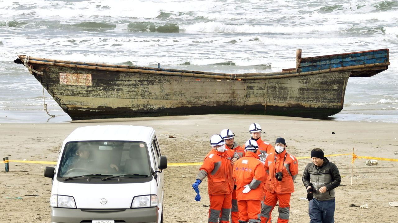 Japanese officials gather on Nov. 27, 2017, near a boat washed ashore in Oga, Akita Prefecture. Authorities found eight bodies in the unidentified wooden boat. (Kyodo)
==Kyodo