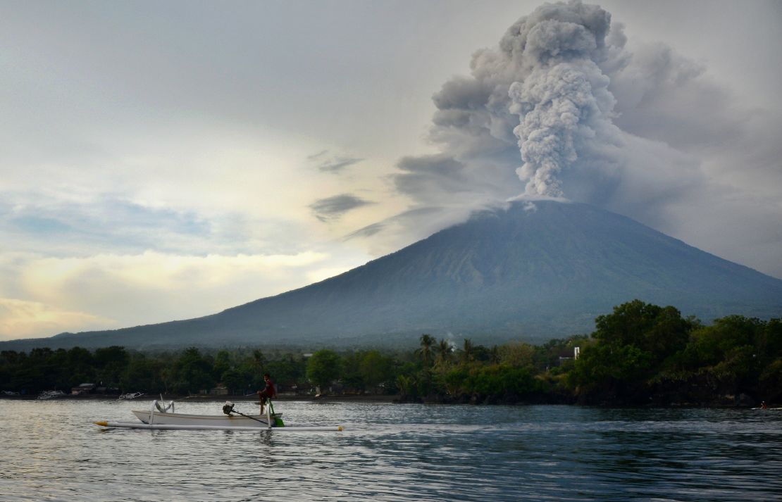 A fisherman drives a traditional boat as Mount Agung erupts in Bali on November 28.
