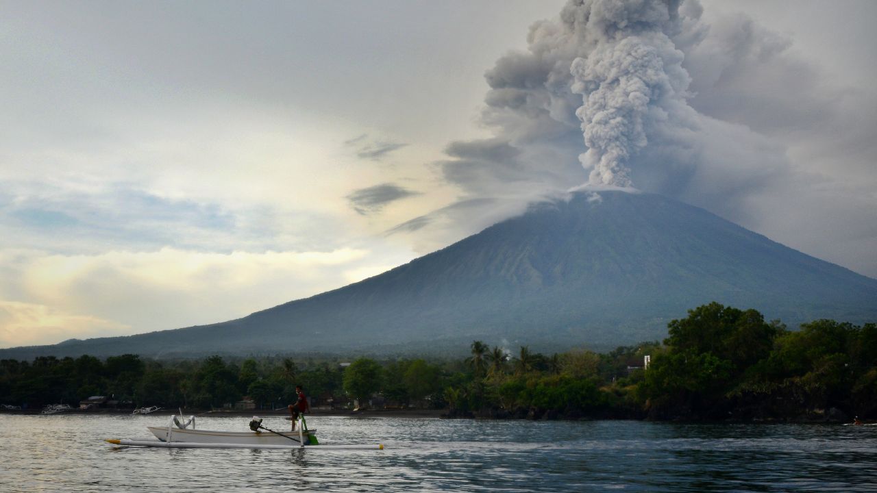 A fisherman drives a traditional boat as Mount Agung erupts in Bali on November 28.