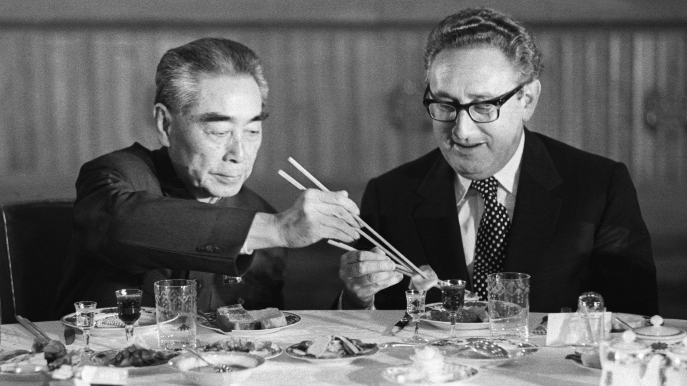 Kissinger accepts food from Chinese Premier Zhou Enlai during a state banquet in Beijing in 1973.