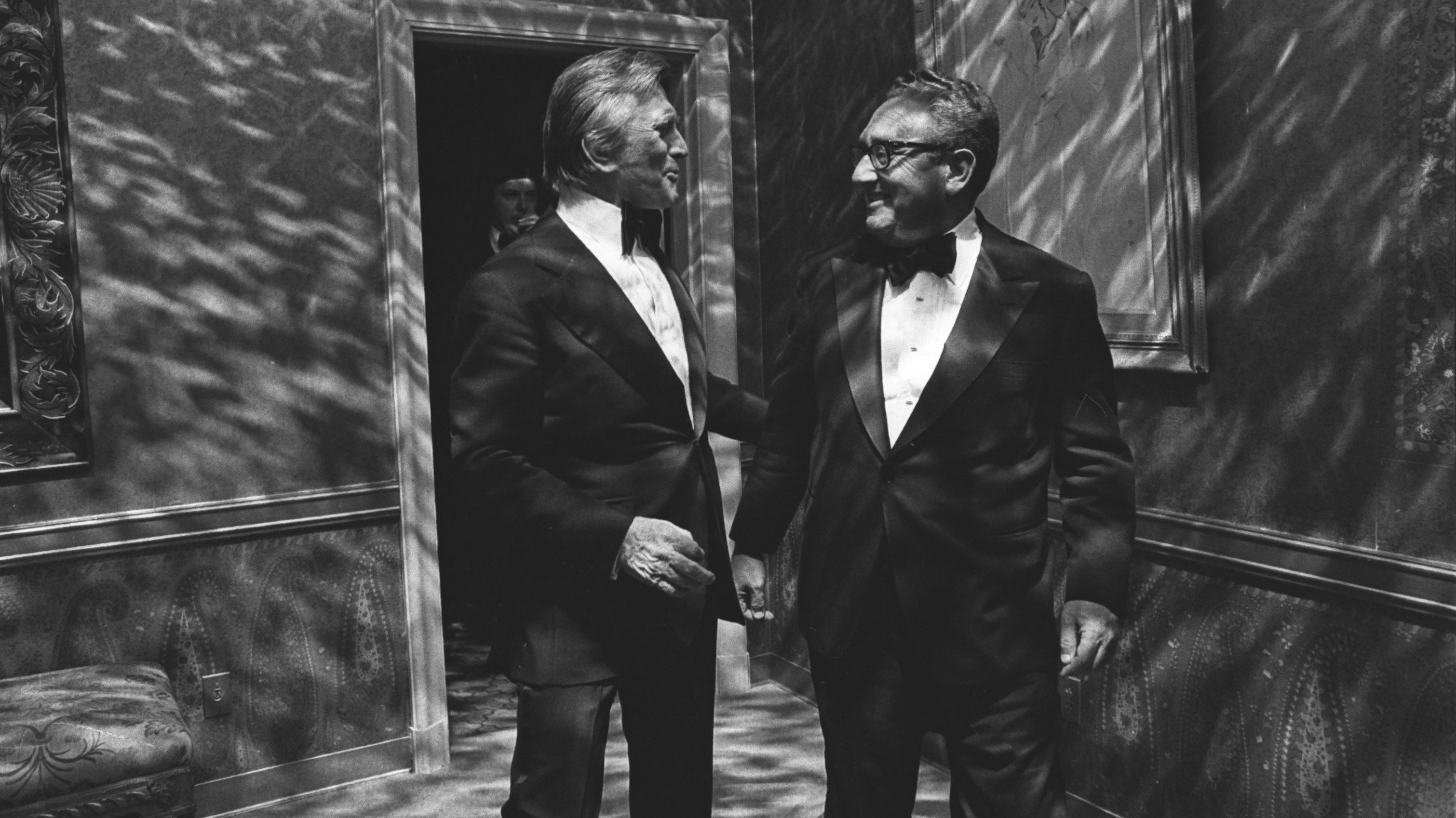 Kissinger talks with actor Kirk Douglas at a dinner party in 1977.