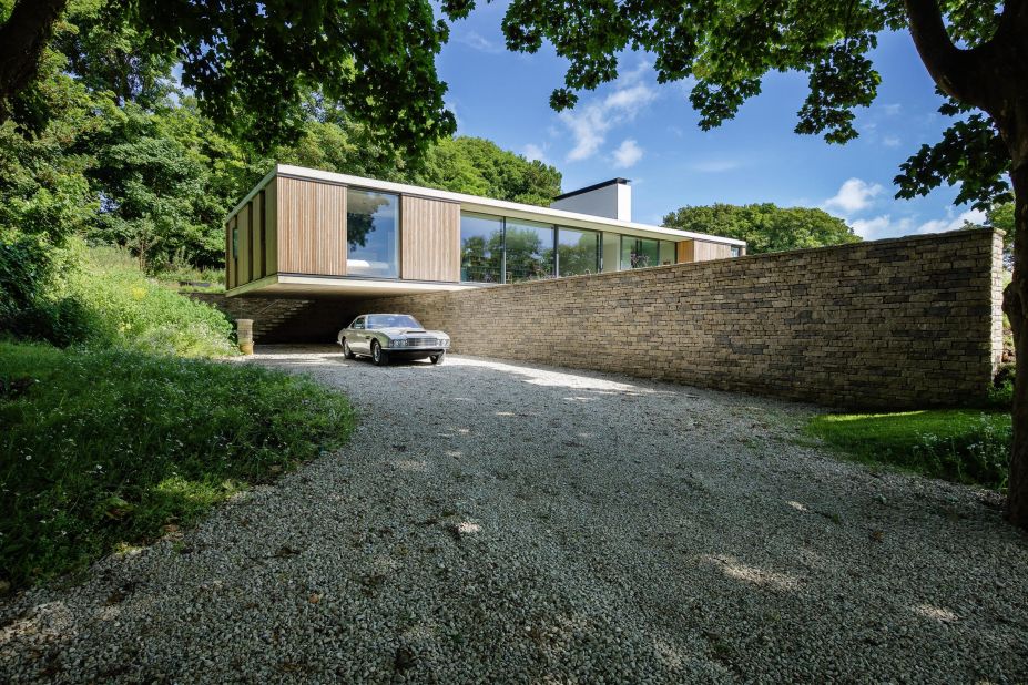 Residents at The Quest in rural England utilize this cantilevering part of the house to protect the precious Aston Martin. 