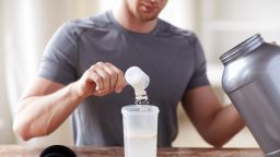 sport, fitness, healthy lifestyle and people concept - close up of man with jar and bottle preparing protein shake (Newscom TagID: ipurestockxthree992786.jpg) [Photo via Newscom]