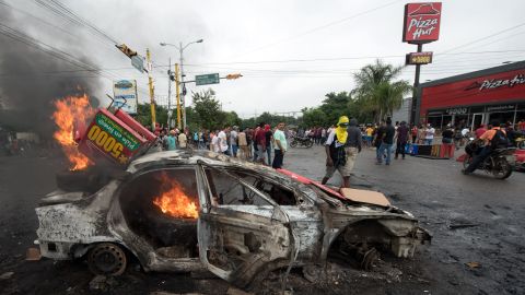 A car burns after being set on fire by supporters of Honduran presidential candidate Salvador Nasralla during post-election protests.