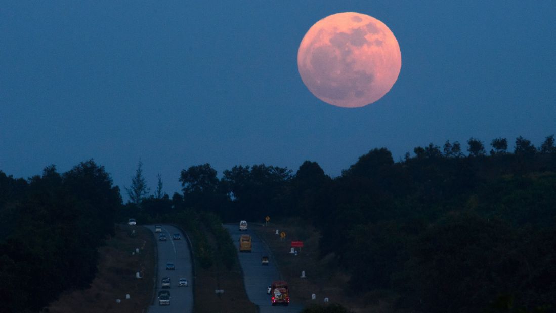 The supermoon rises over a highway near Yangon, Myanmar. The lunar phenomenon occurs when a full moon is at its closest point to Earth.