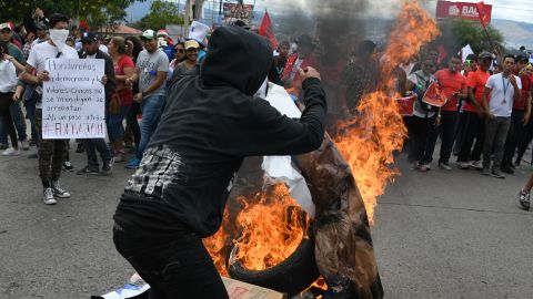 A Narsalla supporter is shown in this pictures, burning the campaign poster of the incumbent, President Juan Orlando Hernandez, on December 3.