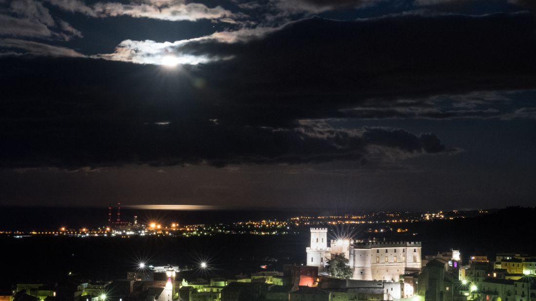 The year's only supermoon is bright behind the clouds above the Castle of Corigliano, in Calabria, southern Italy.