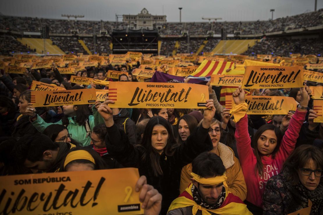 People at a concert in support of jailed leaders hold banners reading "Freedom for the Political Prisoners."