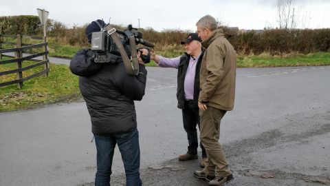Farmer Francie Ward shows CNN's Nic Robertson the border along his road.