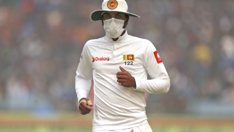 Captain of Sri Lanka's cricket team, Dinesh Chandimal wears an anti-pollution mask during the cricket match in New Delhi on Sunday, December 3.