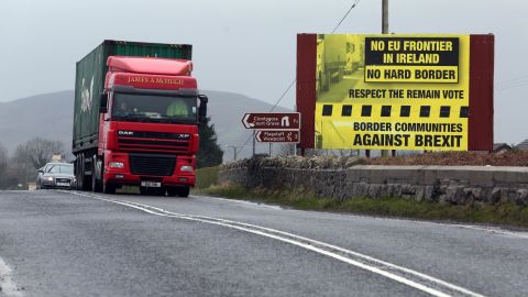 Traffic crosses the border into Northern Ireland from the Irish Republic next to a poster protesting against a hard brexit near Dundalk on January 30, 2017.