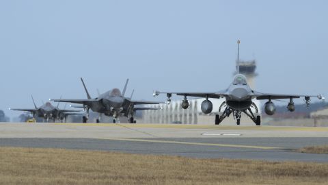 A US Air Force F-16 and four F-35A fighter jets taxi toward the end of the runway during exercise Vigilant Ace at Kunsan Air Base in South Korea.