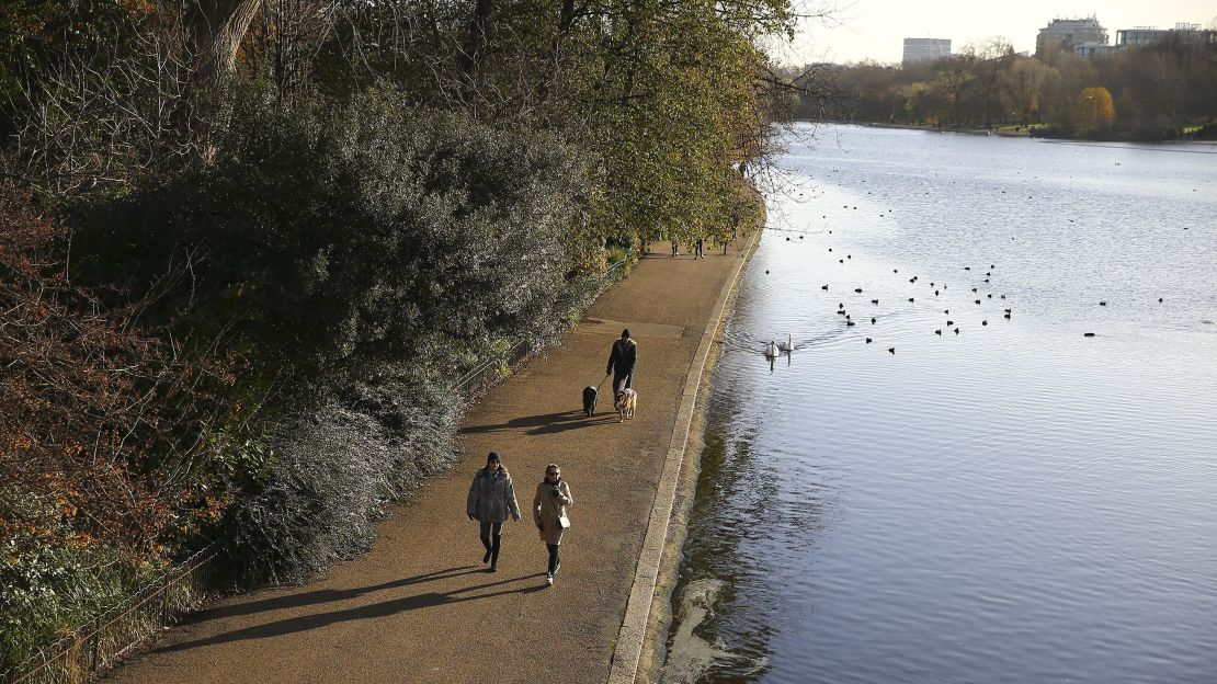 People take a walk in Hyde Park during the last days of autumn in October.