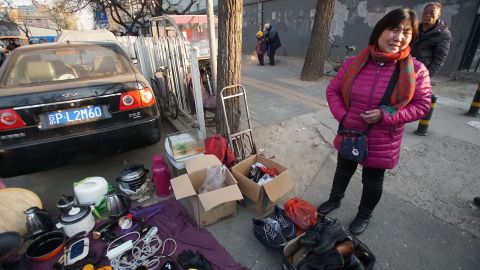 Zhao Guihua, an evicted migrant worker, sells her possessions on the street 50 meters from her old home. She said she and her husband are leaving Beijing because they can't afford a new home.