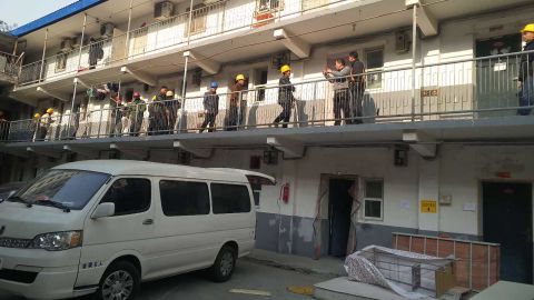 Demolition crews wield sledgehammers as they enter a residential compound to enforce an eviction.