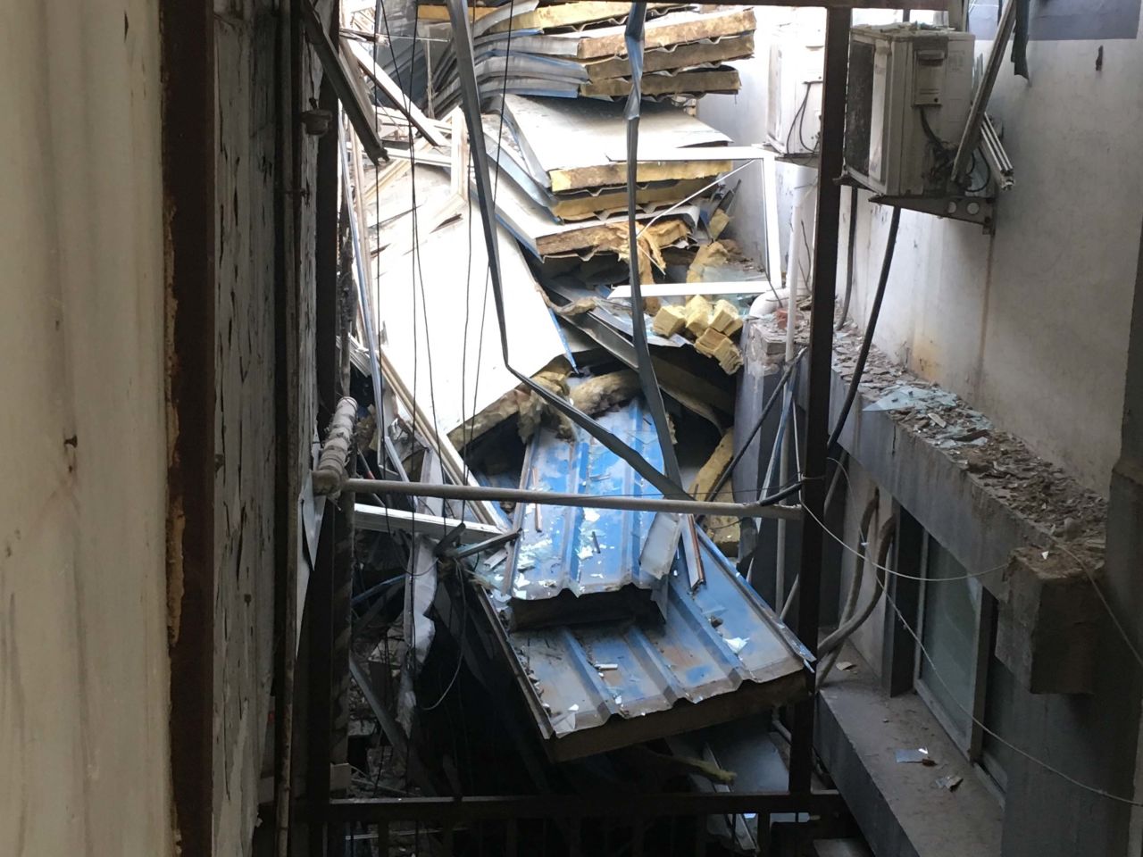 Debris from insulated ceilings and broken glass is seen littering floors of a building after demolition crews forced the eviction of migrant workers.