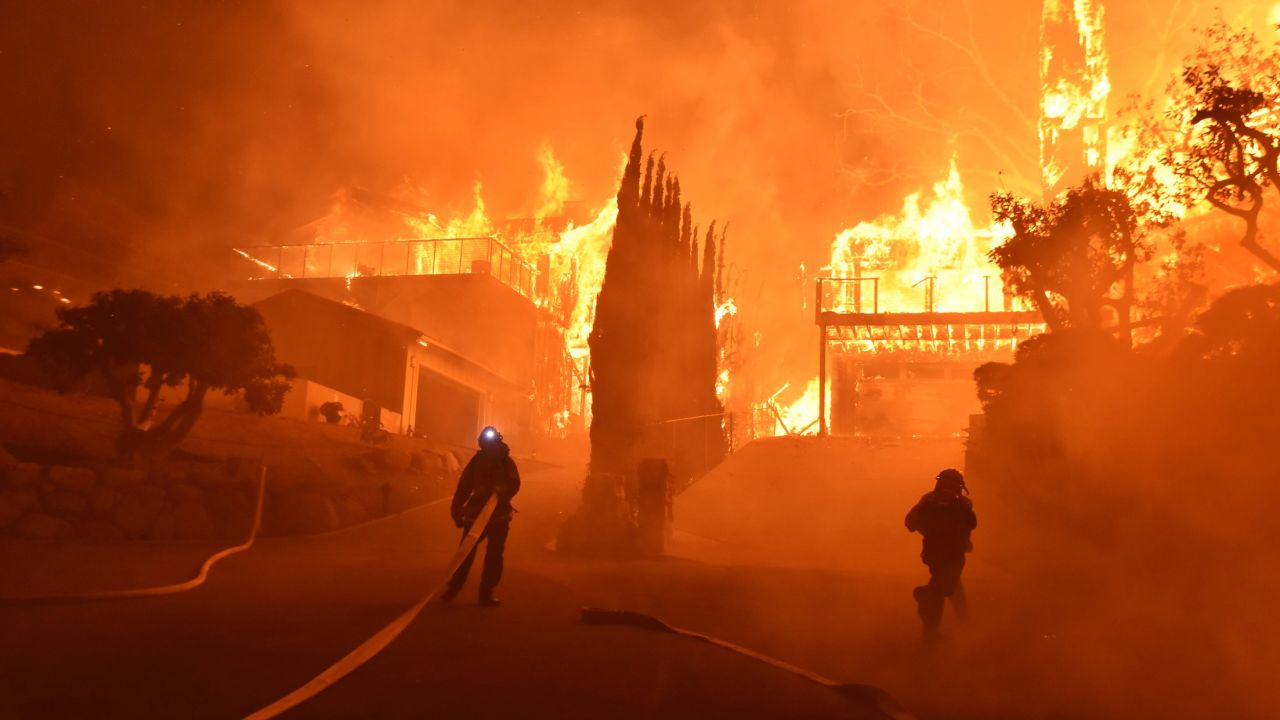 Firefighters work to put out a blaze engulfing homes in Ventura on December 5.
