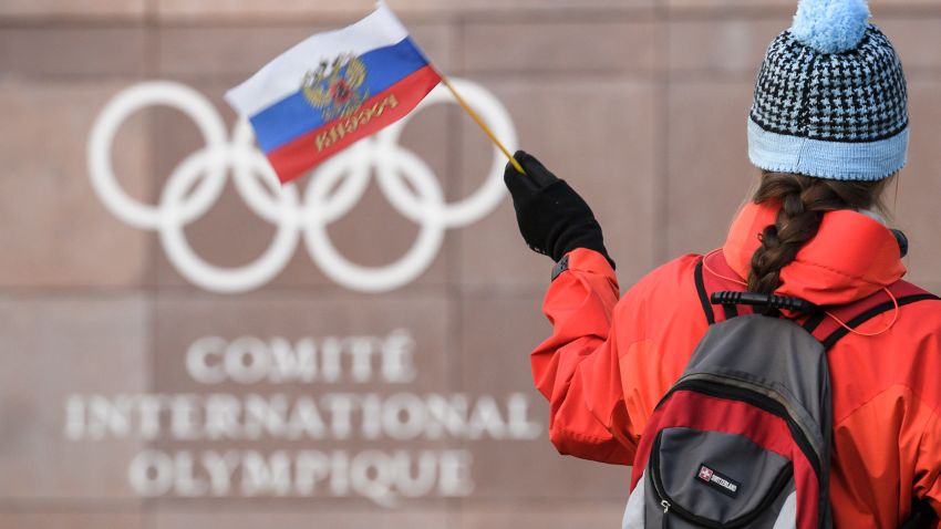 A supporter waves a Russian flag in front of the logo of the International Olympic Committee (IOC) at their headquarters on December 5, 2017 in Pully near Lausanne.
The International Olympic Committee opened a high-stakes summit on December 5 on whether to bar Russia from the Winter Olympics over allegations its medal haul at the 2014 Sochi Games was fuelled by state-sponsored doping. / AFP PHOTO / Fabrice COFFRINI        (Photo credit should read FABRICE COFFRINI/AFP/Getty Images)