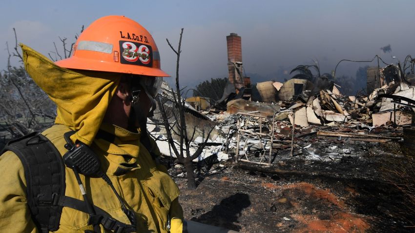 A firefighter looks at a house burnt to the ground during the Thomas wildfire in Ventura, California on December 5, 2017.
Fast-moving, wind-fueled brush fire exploded to about 10,000 acres in Ventura County Monday night, forcing hundreds of people to flee their homes, officials said.  / AFP PHOTO / MARK RALSTONMARK RALSTON/AFP/Getty Images