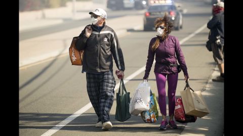 James and Josie Ralstin carry belongings retrieved from their home in Ventura on December 5.
