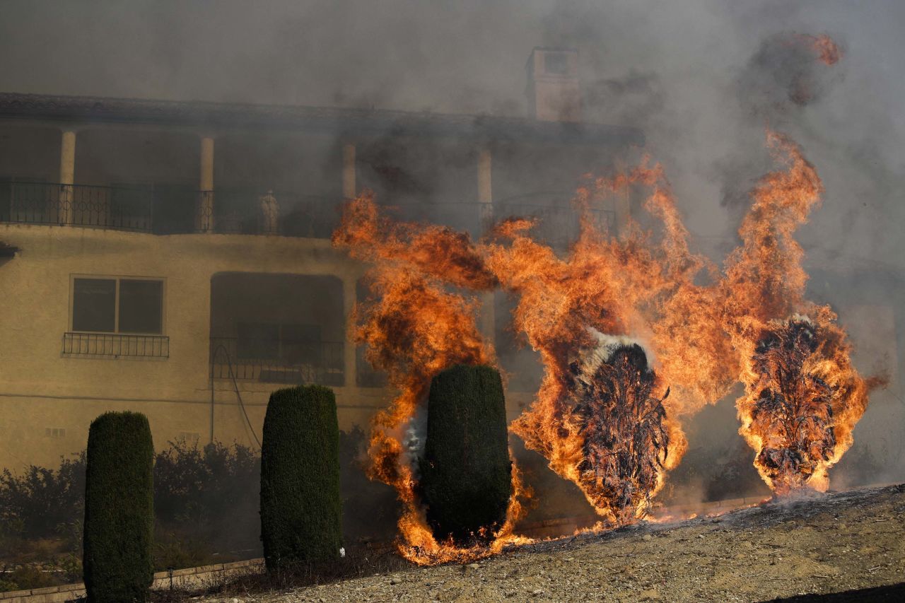 Shrubs burn near a home in Ventura on December 5.