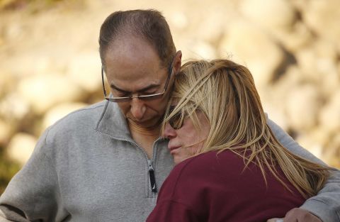 Antoine Hanna comforts his wife, Tammy, after firefighters saved their home in Ventura on December 5.