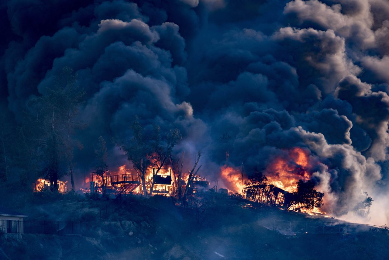 Smoke billows from a burning house in Los Angeles as the Creek Fire moves through the area on December 5.